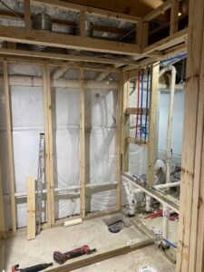 Basement framing and plumbing rough-in for a new bathroom by Segovia LLC interiors in Madison, WI.