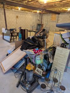 A basement filled with a large pile of various junk items for an estate cleanout by Junk Runner, LLC in East Berlin, PA.