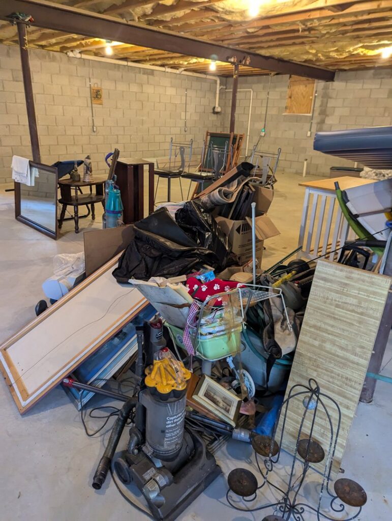 A basement filled with a large pile of various junk items for an estate cleanout by Junk Runner, LLC in East Berlin, PA.