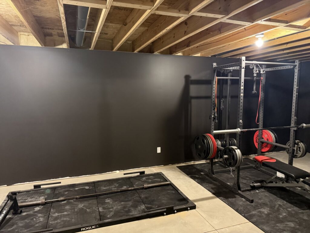 Newly painted black walls in a basement gym by FG Drywall, Finishing and Painting in Champaign, IL.
