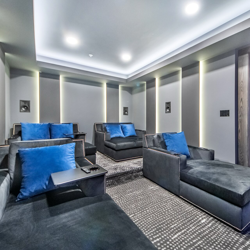 Basement home theater with comfortable tiered seating and surround sound by BasementRemodeling.com in Rockville, MD.
