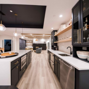 Basement kitchen remodel with dark cabinetry, white countertops, and stainless steel appliances by BasementRemodeling.com in Rockville, MD.