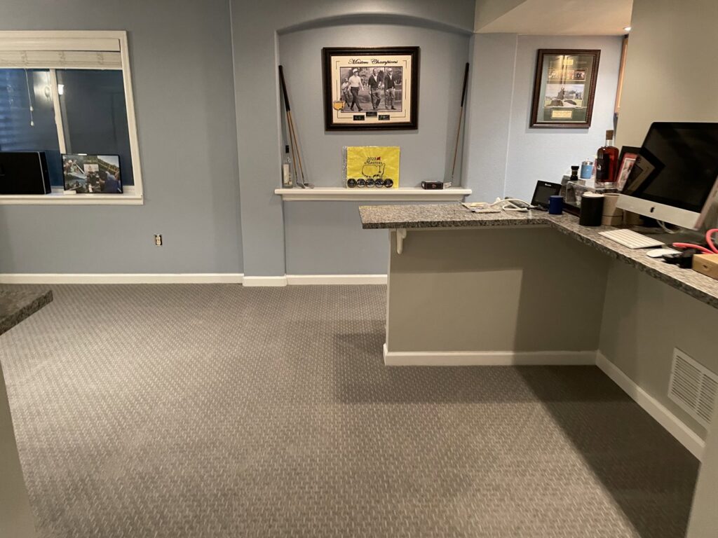 A finished basement living area with a built-in shelf and bar, showcasing renovation work by RAW Renovation in Denver, CO.