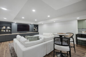 A finished basement living area with a built-in media center and bar by J Brothers Design- Build- Remodel, Inc. in Corcoran, MN