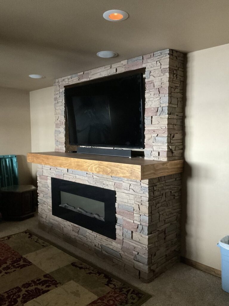 A remodeled basement room featuring new ceiling tiles and recessed lighting by ROTH WORX LLC in Bismarck, ND.