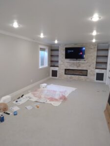 A completed basement remodel featuring a stone fireplace, built-in shelves, and new carpet by Eagle Rock Handyman Services in Caldwell, ID.