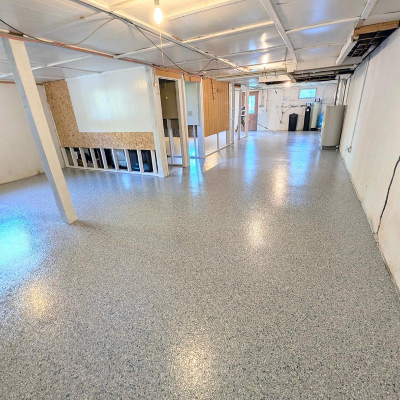 A basement remodel showing new epoxy flooring and exposed framing by Roche Epoxy Floors in Allentown, PA.