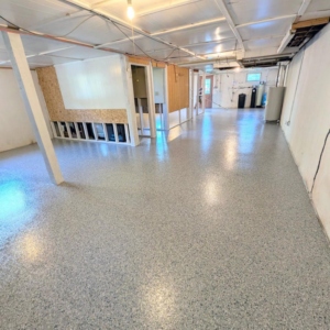 A basement remodel showing new epoxy flooring and exposed framing by Roche Epoxy Floors in Allentown, PA.