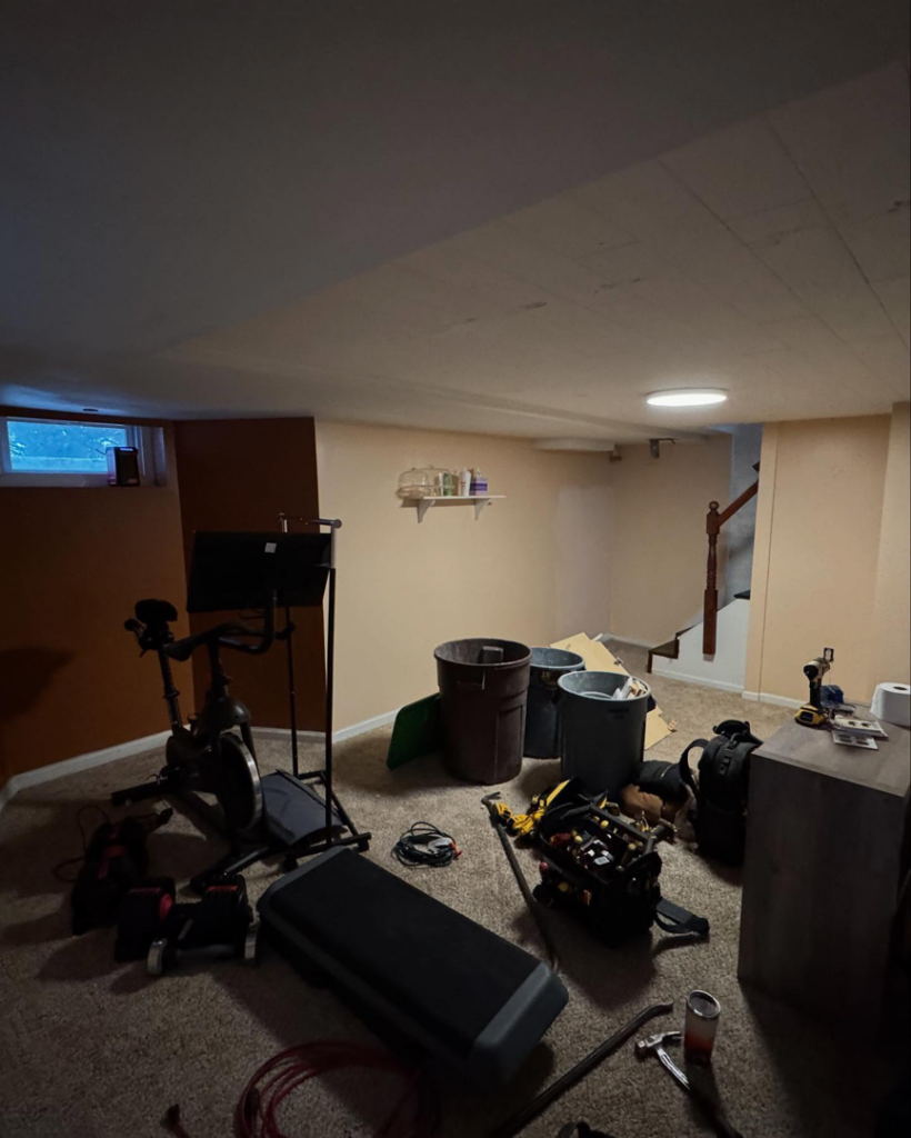 A basement undergoing remodeling with tools, materials, and unfinished walls, showcasing work by Chesapeake Premier Remodeling in Baltimore, MD