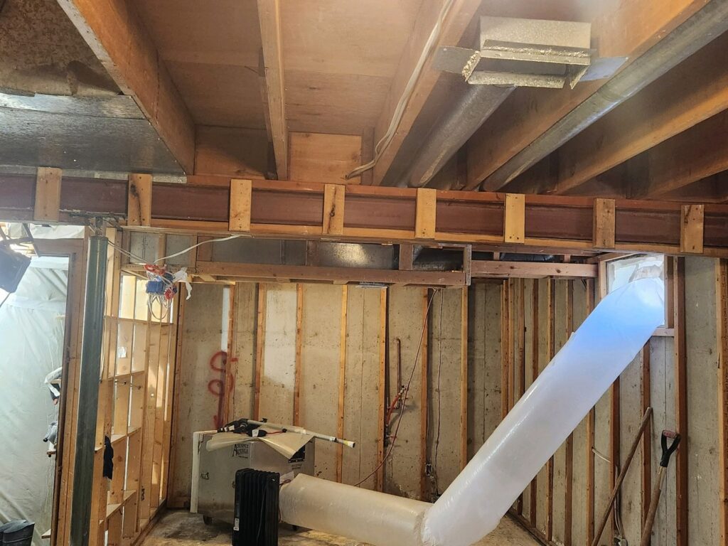 A basement undergoing renovation with exposed wood framing and ductwork by Asbestos Abatement, Inc in Englewood, CO.