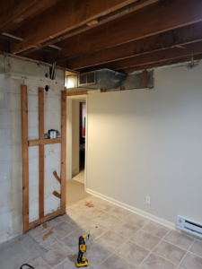 Basement renovation showing exposed concrete block wall, wood framing, and ductwork by Jake Fortin Carpentry Services in Pittsburgh, PA.
