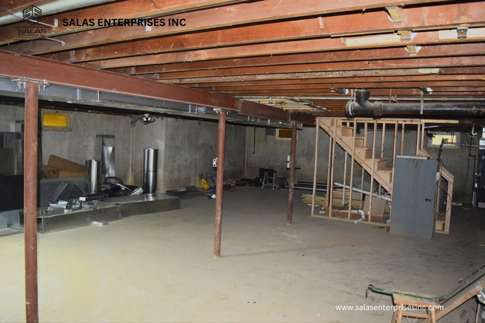 Basement renovation with exposed beams, new ductwork, and framed staircase by Salas Enterprises, Inc in Elgin, IL.