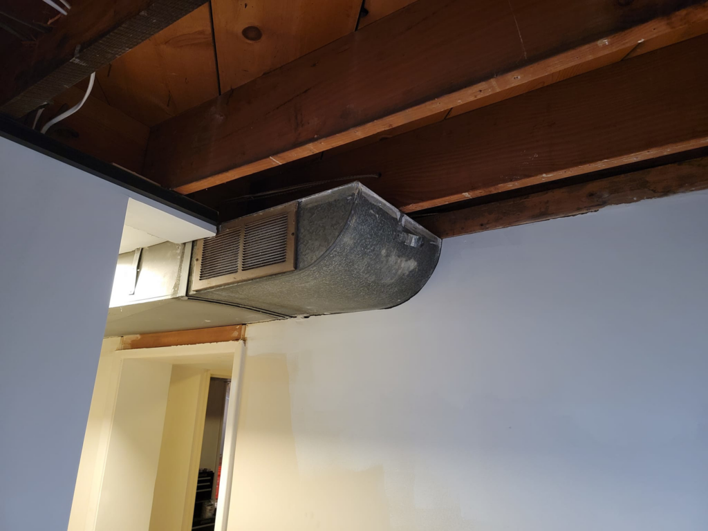 A basement renovation in progress showing exposed ceiling joists and ductwork by Jake Fortin Carpentry Services in Pittsburgh, PA.