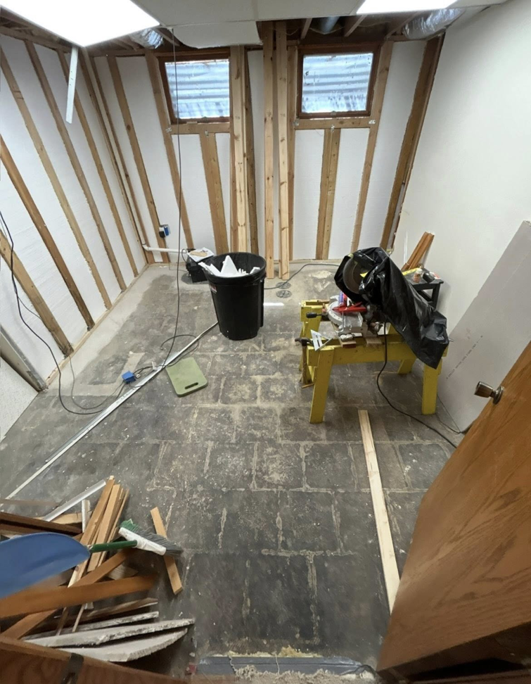 A basement renovation in progress with exposed framing and tools by I Need a Guy Handyman Services LLC in Moorhead, MN