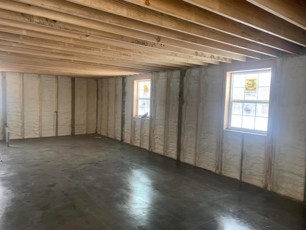 Spray foam insulation applied to basement walls and floor joists in a construction project by Spray Foam Solutions Of Erie in Erie, PA.