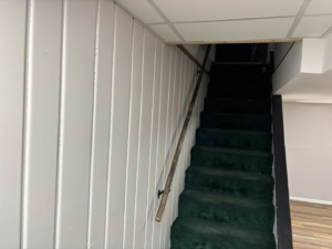 A renovated basement staircase featuring new wall paneling and a drop ceiling by J Webb's Home Improvements LLC in Peoria, IL.