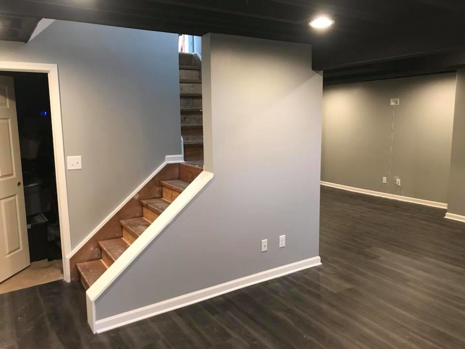A newly installed wooden staircase in a finished basement area by M Zimmer Construction LLC in Rochester, NY.