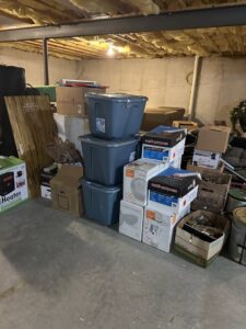 A large pile of storage bins and boxes in a basement, indicating a junk removal project by Vatter Hauling Service in Lancaster, PA.
