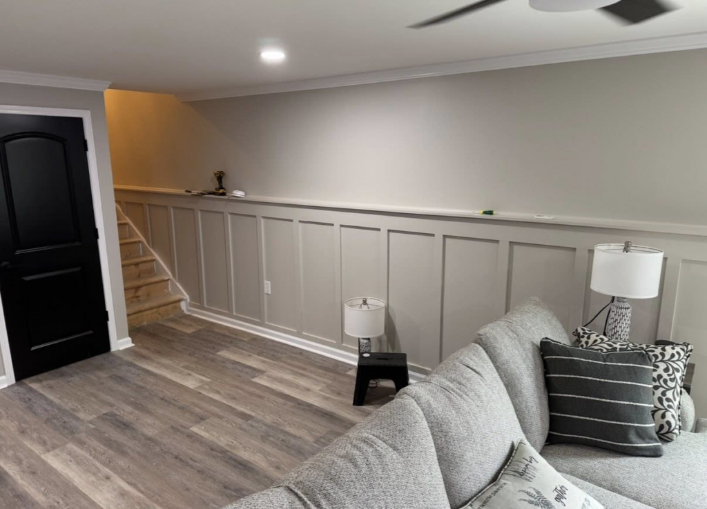 A finished basement living area featuring decorative wainscoting and new flooring installed by Jason Roberts Painting and Remodeling in Louisville, KY.