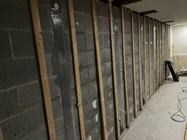 Interior basement wall with wooden studs framed for foundation repair or finishing by Pioneer Basement Solutions in Canton, OH.