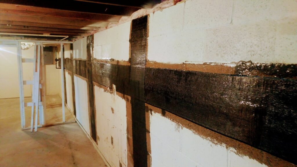 Basement wall reinforcement with carbon fiber straps by E.S. Leonard Waterproofing in De Soto, MO.