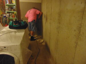 A worker performing basement wall repair work for E.S. Leonard Waterproofing in De Soto, MO.