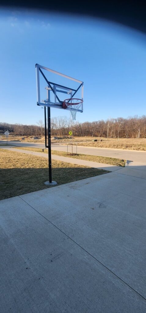 A new basketball hoop professionally installed on a concrete pad by SAM'S Handywork LLC in Independence, IA.