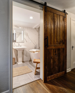 A newly installed barn door leading to a remodeled bathroom by Scott Hall Remodeling in Columbus, OH.