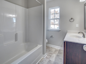 A newly installed bathroom with a bathtub, vanity, and toilet by GTB Construction in Portsmouth, VA.