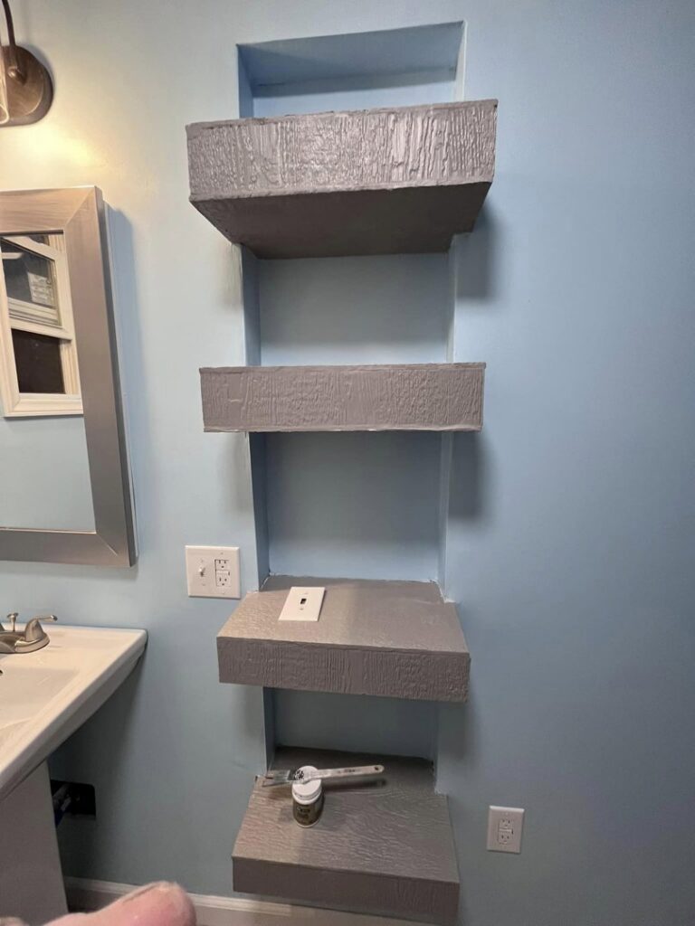 Built-in shelves being installed or painted in a bathroom, a service provided by The Golden Touch handyman services in Huntington, WV.