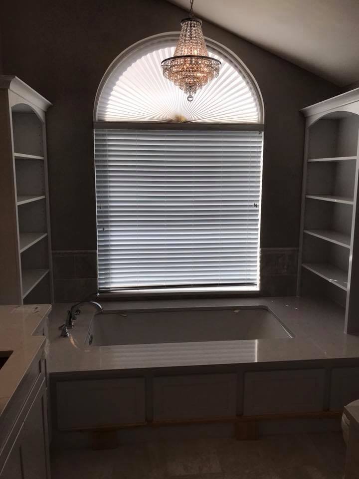 A luxurious bathroom remodel with a built-in tub, custom shelving, and a chandelier installed by Pro Remodel LLC in St. Charles, MO.