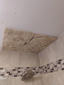 An OSB board patch covering a hole in a bathroom ceiling, a repair service by Drywall Paint Plus in Worcester, MA.