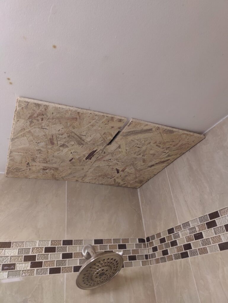 An OSB board patch covering a hole in a bathroom ceiling, a repair service by Drywall Paint Plus in Worcester, MA.