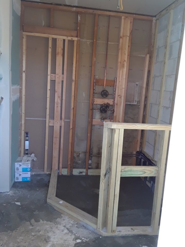Bathroom under construction with framing and plumbing rough-in by Corley Construction Inc in Fort Lauderdale, FL