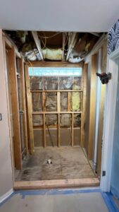 A bathroom during demolition, revealing exposed framing, insulation, and plumbing by TEXAN Home Improvements LLC in San Antonio, TX.