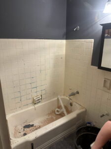 A bathroom undergoing demolition with an old tub and exposed tiles by Urban Restoration, LLC in Indianapolis, IN