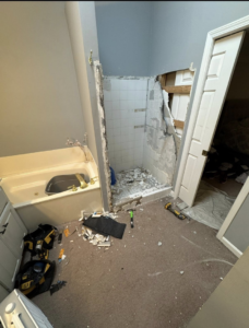 A bathroom undergoing demolition and remodeling, with a shower wall torn out, by Jason Roberts Painting and Remodeling in Louisville, KY.