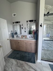A renovated bathroom featuring a double vanity with modern mirrors and lighting by A&R Home Improvements in El Paso, TX