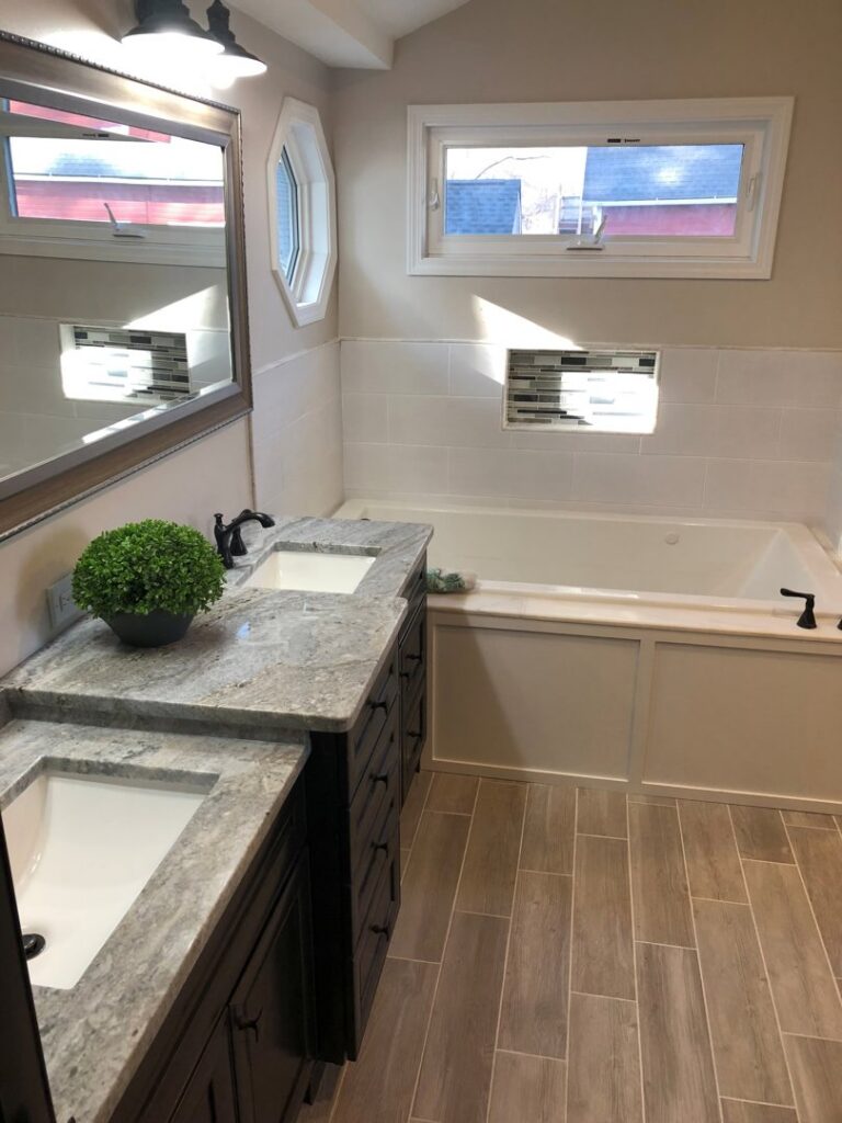 Bathroom renovation featuring a double vanity and new tub installation by APS Residential Services in Livonia, MI.