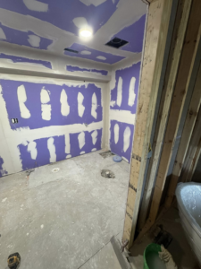Bathroom drywall installation in progress with purple board and mudding, handled by Home Improvements by Duane in Racine, WI.