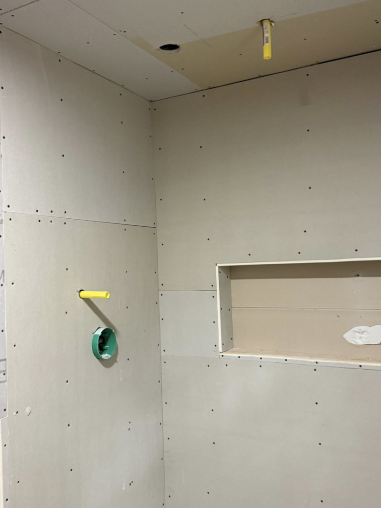 Drywall installation in a bathroom with a shower niche and plumbing rough-ins by Jay's Construction in Cincinnati, OH.