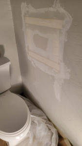 Bathroom drywall repair and patching near a toilet by M&M Drywall and Construction in Enid, OK