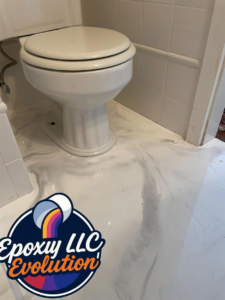 A white, swirled epoxy floor installed in a bathroom around a toilet by Epoxy Evolution in Albany, NY.