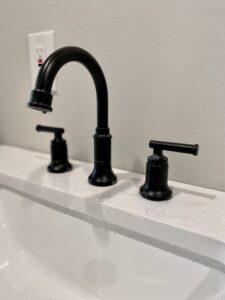 A sleek black bathroom faucet installed on a new vanity by Elite Handyman & Remodeling in Dallas, TX.