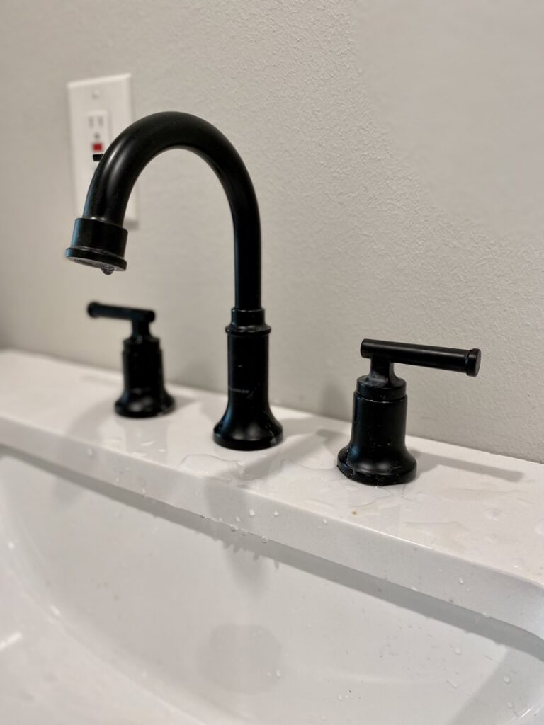 A sleek black bathroom faucet installed on a new vanity by Elite Handyman & Remodeling in Dallas, TX.
