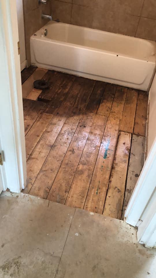 Bathroom floor demolition showing exposed subfloor by Changing Spaces Construction LLC in Portland, OR.