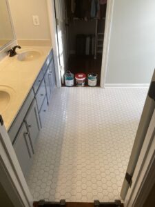 A bathroom with newly installed hexagonal floor tiles and paint cans, showing a renovation project by Lee's Handyman Service LLC in Oxford, MS.