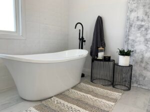 A bathroom featuring a stylish freestanding tub with a black faucet installed by NP General Contracting in Austin, TX.