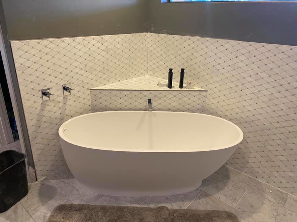 A bathroom featuring a freestanding tub and patterned tile backsplash installed by Dahlman Construction in San Tan Valley, AZ.