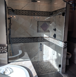 A complete bathroom renovation featuring a glass shower enclosure and bathtub by Glazed Peak Glass Company in Colorado Springs, CO.